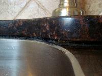 Gap between center of sink and granite, near faucet
