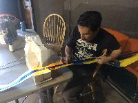 Fireman Dave sewing webbing onto vinyl strips