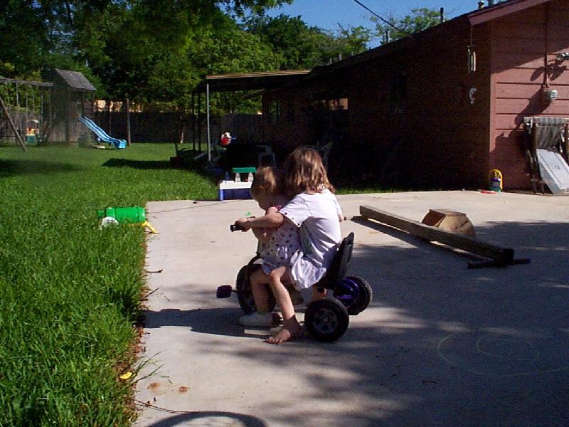 two girls on a tricycle