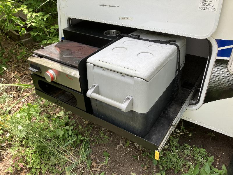 Exterior 'kitchen' area with propane griddle and powered cooler.